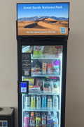 JL Smart Vending machine displaying Great Sand Dunes National Park advertisement on digital screen